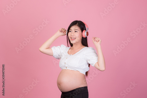 Happy pregnant woman on a pink background, maternity readiness
