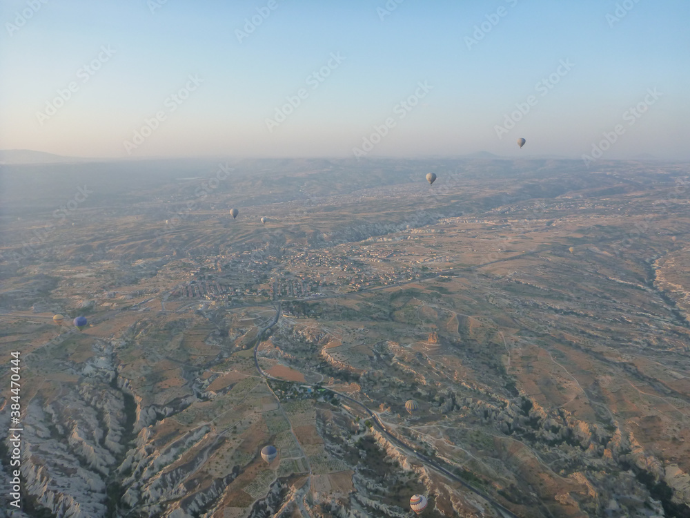 Aerial view of hot air balloons and the surreal landscape of Cappadocia, Turkey, at sunrise