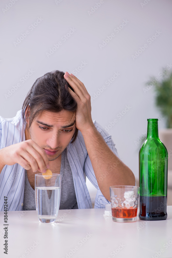 Young male alcoholic drinking whiskey at home Young male alcoholic drinking whiskey at home
