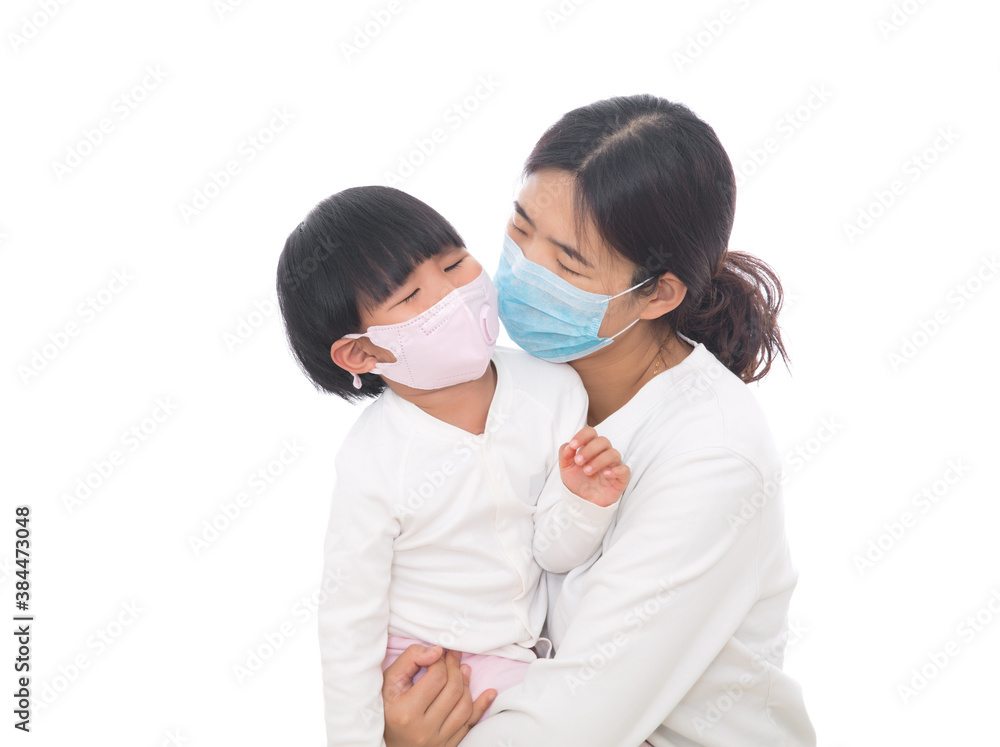 Young mother wearing a mask holding a little daughter wearing a mask Young mother wearing a mask holding a little daughter wearing a mask