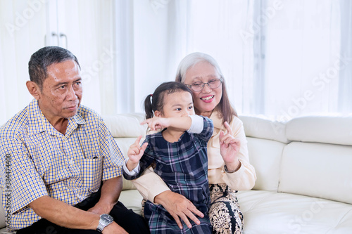 Child watching TV with her grandparents at home © Creativa Images