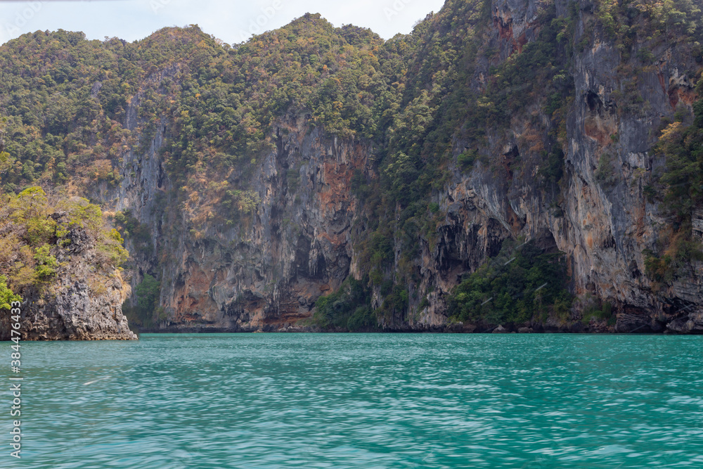 beautiful yellow gray cliffs with trees in the azure sea, Thailand