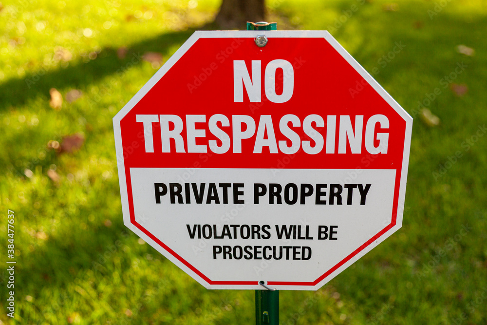 Close up isolated image of a metal red and white octagonal  warning yard sign that says 