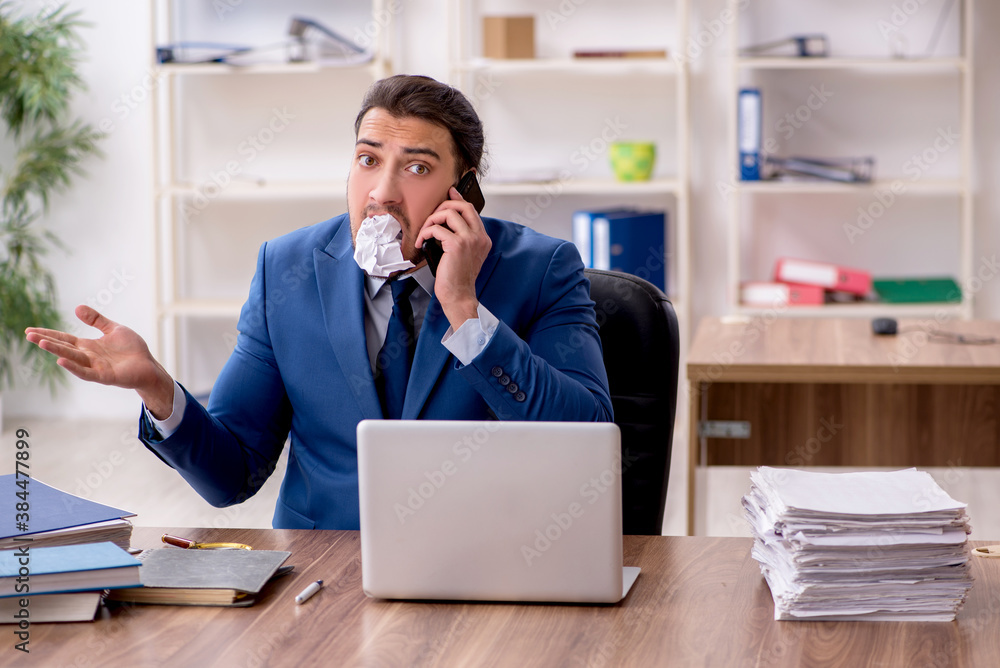 Young male employee unhappy with excessive work Young male employee unhappy with excessive work