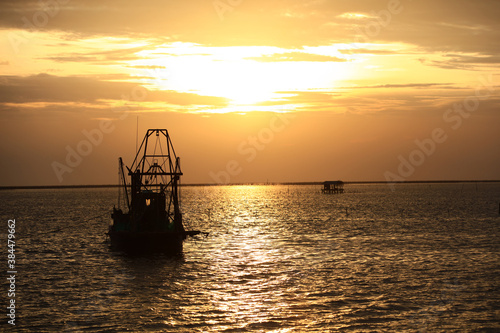 Silhouette Fisherman boat againt sunset or sunrise at Chonburi, Thailand