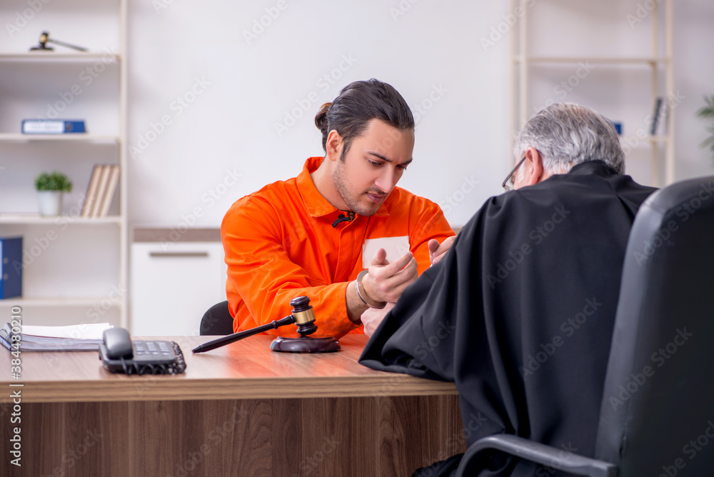 Old male judge meeting with young captive in courthouse Old male judge meeting with young captive in courthouse