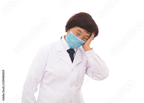 Tired female doctor wearing a mask in front of white background