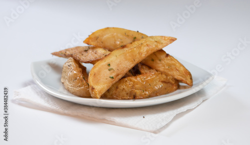 Rustic or Country Style Herb Fries potatoes on a Small Plate on a White Surface or background