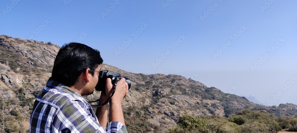 Fototapeta premium Photographer looking through binocular