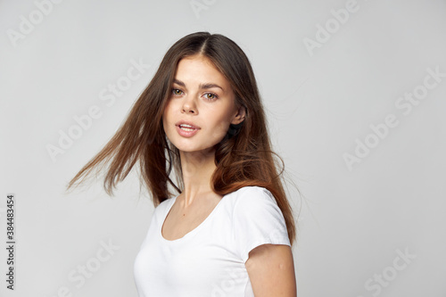 Pretty woman with open mouth on a light background brunette