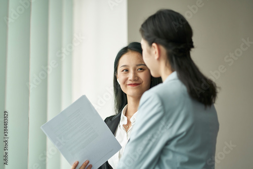 Canvas Print two asian corporate executives discussing business in office