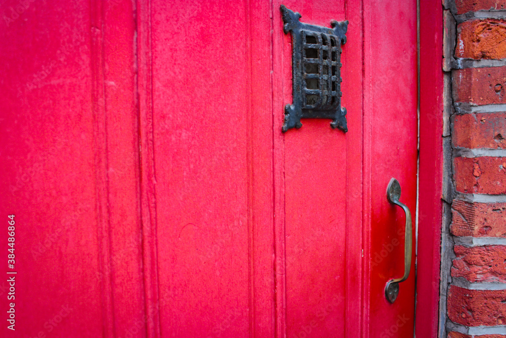 Red old wooden doors in a brick house