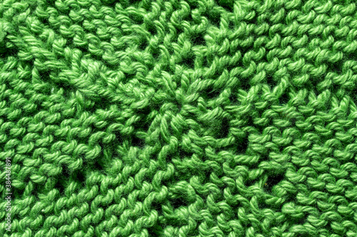 Full frame macro art abstract view of a green crocheted yarn doily texture on a dark blue background, with copy space.