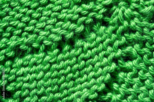 Full frame macro art abstract view of a green crocheted yarn doily texture on a dark blue background, with copy space.