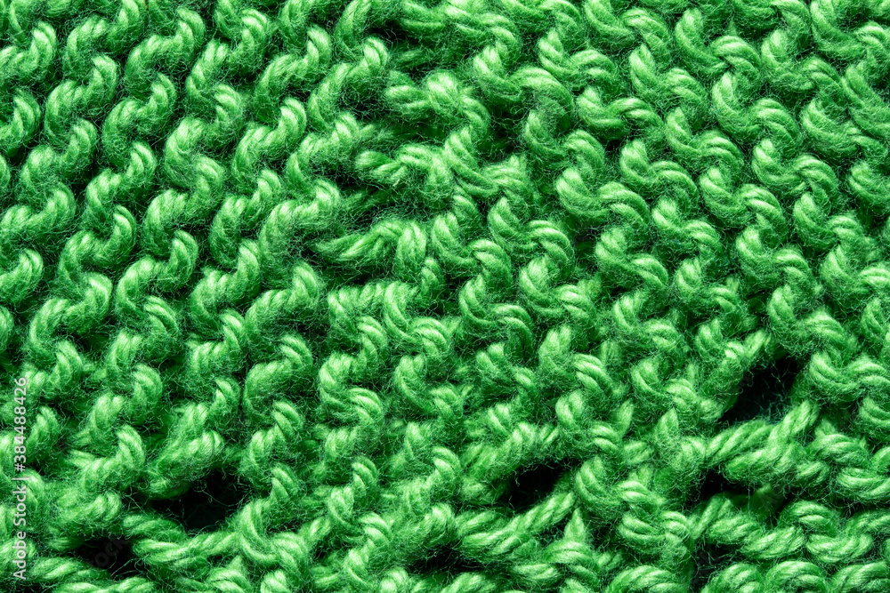Full frame macro art abstract view of a green crocheted yarn doily texture on a dark blue background, with copy space. Full frame macro art abstract view of a green crocheted yarn doily texture on a dark blue background, with copy space.