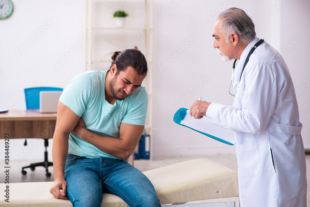 Injured young man visiting old doctor Injured young man visiting old doctor