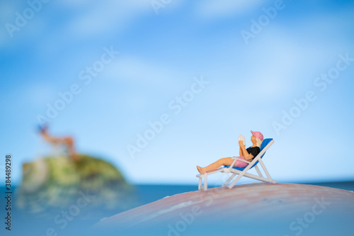 Miniature people sunbathing on a seashell with blue sky background  , summer vacation concept © Sirichai Puangsuwan