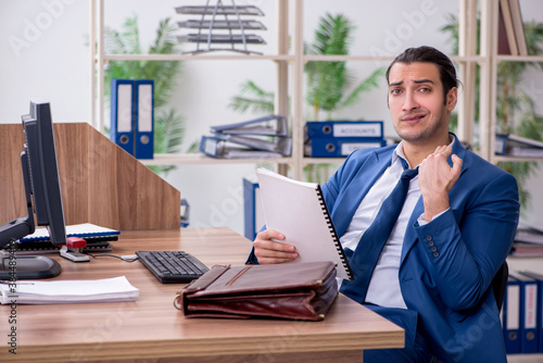 Young male employee businessman at workplace