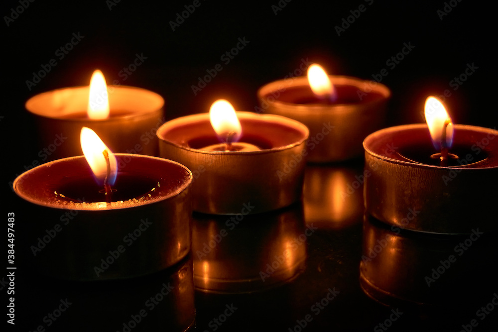 Burning candles on a black background, selective focus, romantic setting, romantic atmosphere, shot with shallow depth of field. Burning candles on a black background, selective focus, romantic setting, romantic atmosphere, shot with shallow depth of field.