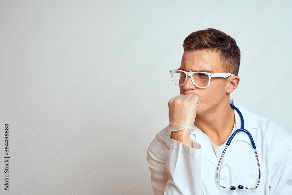 doctor in a medical gown with a stethoscope and glasses on a light background cropped view portrait doctor in a medical gown with a stethoscope and glasses on a light background cropped view portrait