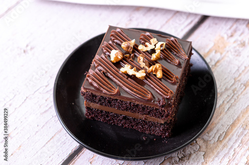 chocolate cakes brownies pastries dessert on black ceramic plate with nuts topping