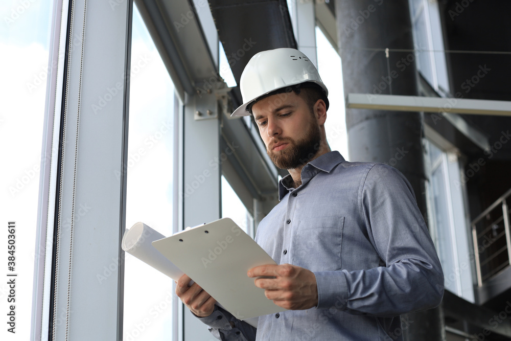 Shot of male architect wearing hardhat and inspecting new building. Shot of male architect wearing hardhat and inspecting new building.