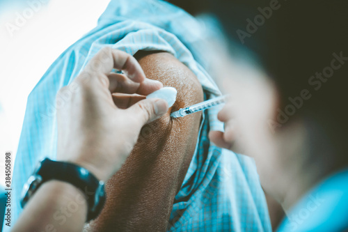 The doctor is injecting the flu vaccine on the patient's shoulder : health care concept