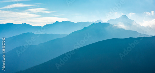 Kasprowy Wierch (Kasprov vrch) - the characteristic peak of the building at the top and the nearby ridges in the morning fog lit by the rays of the sun. Tatra Mountains, Poland. © gubernat