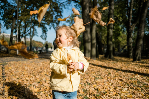 Little girl walks in the park in autumn and throws leaves © gesrey