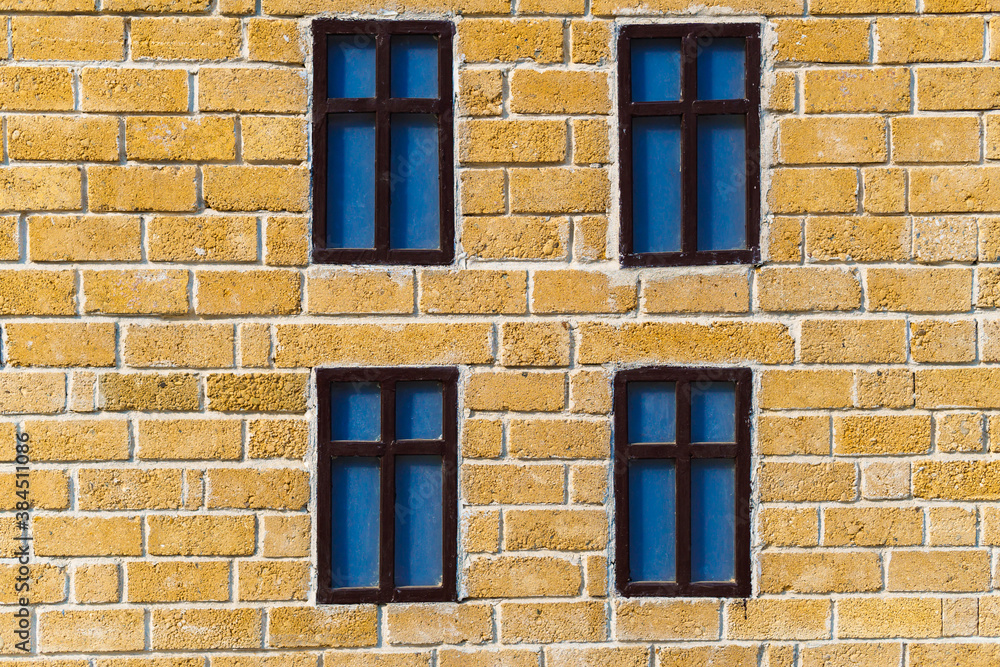 background from a miniature houses in a city park, yellow brick wall and windows