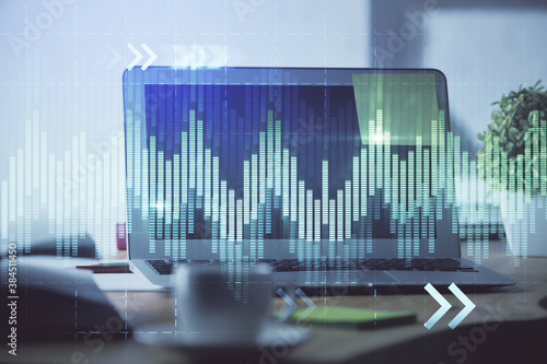 Stock market chart hologram drawn on personal computer background. Double exposure. Concept of investment.