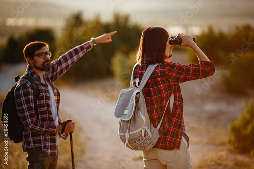 Portrait of happy young couple having fun on their hiking trip. Caucasian and asian hiker couple enjoying themselves on summer vacation.