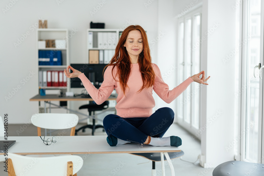 Serene young office worker practicing meditation
