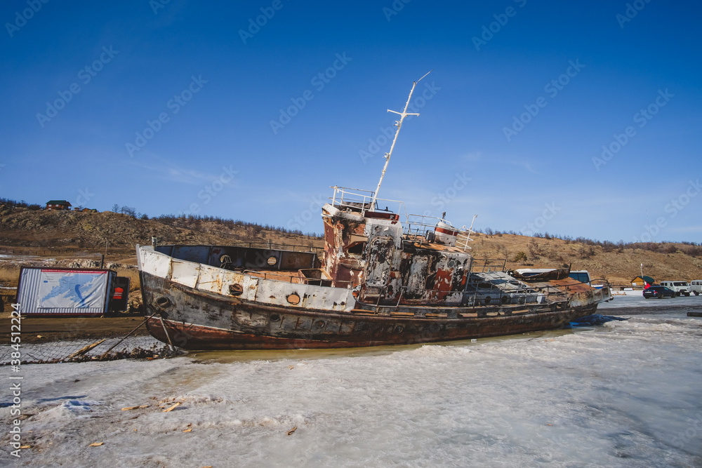 Wrecked boat on the shore of Kurkut town near lake Baikal, Irkutsk, Russia. 