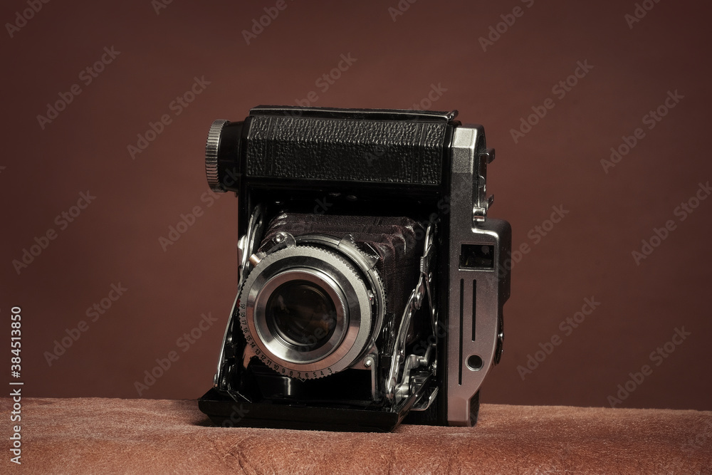 vintage rangefinder film folding camera on brown background