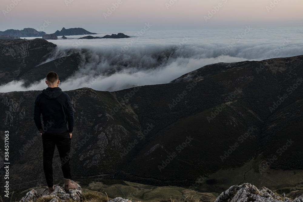 Fototapeta premium Ginger bearded man staring at the horizon during a sunrise in the mountains.