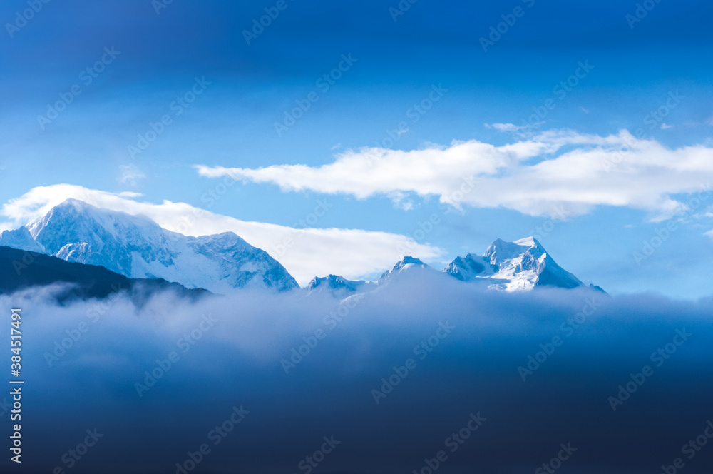 Mount Cook (Aoraki) snow covered top surrounded by clouds on the foggy morning, the highest mountain in New Zealand, view from Fox Glacier Village