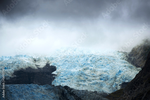 Beautiful Franz Josef Glacier with dramatic grey clouds, South Island, New Zealand 