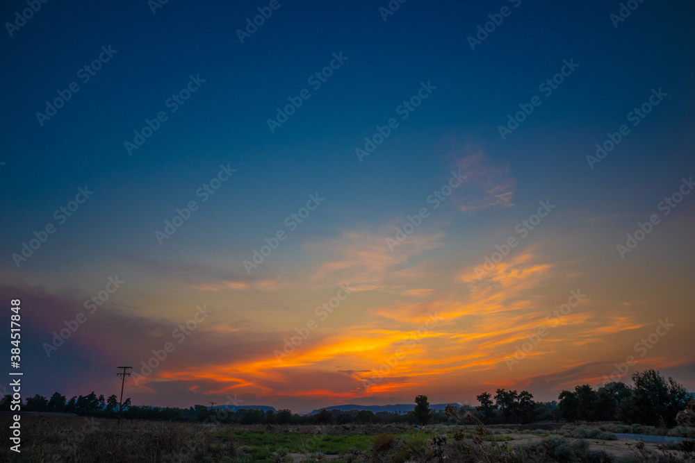 beautiful orange cloudy sunset at the fields 