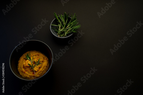 Vegetarian puree soup with butter and carrots on a dark surface.
