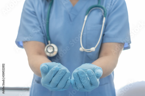 Medical surgical doctor or surgeon with empty hands in hygience lab gloves offering or holding copy space for health care practice, nursing, organ donation, hospital csr, or clinical charity concept photo