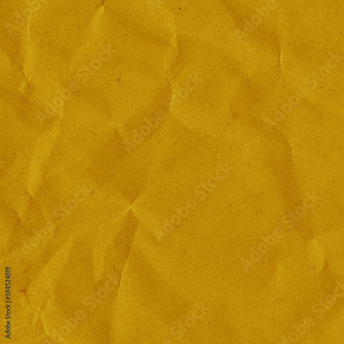Yellow vintage and old looking crumpled paper background. Retro cardboard texture. Grunge paper for drawing. Ancient book page. Present wrapping.