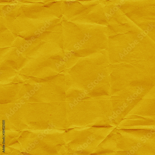 Yellow vintage and old looking crumpled paper background. Retro cardboard texture. Grunge paper for drawing. Ancient book page. Present wrapping.