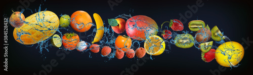 Fototapeta Naklejka Na Ścianę i Meble -  Panorama with fresh fruits in the water - pear, melon, lime, persimmon, lychee, mango, mango, lemon, kiwi, strawberry, a delicious dessert for the New Year, Christmas and Halloween