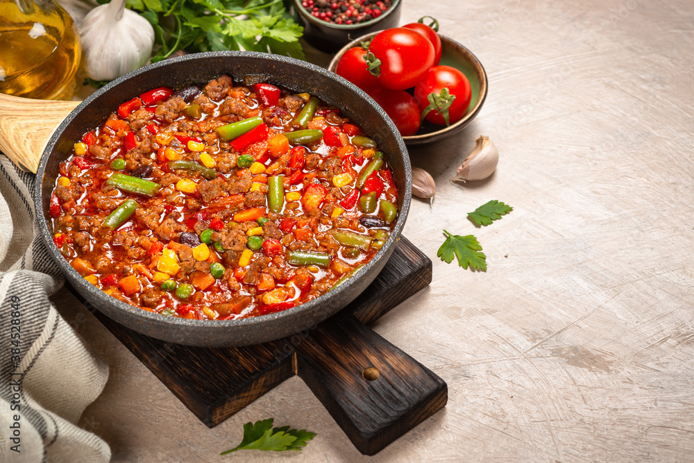 Chili con carne in skillet on light stone table. Chili con carne in skillet on light stone table.