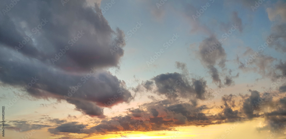 Sunset panorama. Nightly sky with clouds and sun stream
