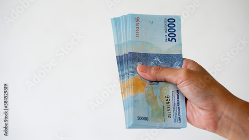 Indonesian rupiah currency, around 50,000 Indonesian money, is held by women's hands