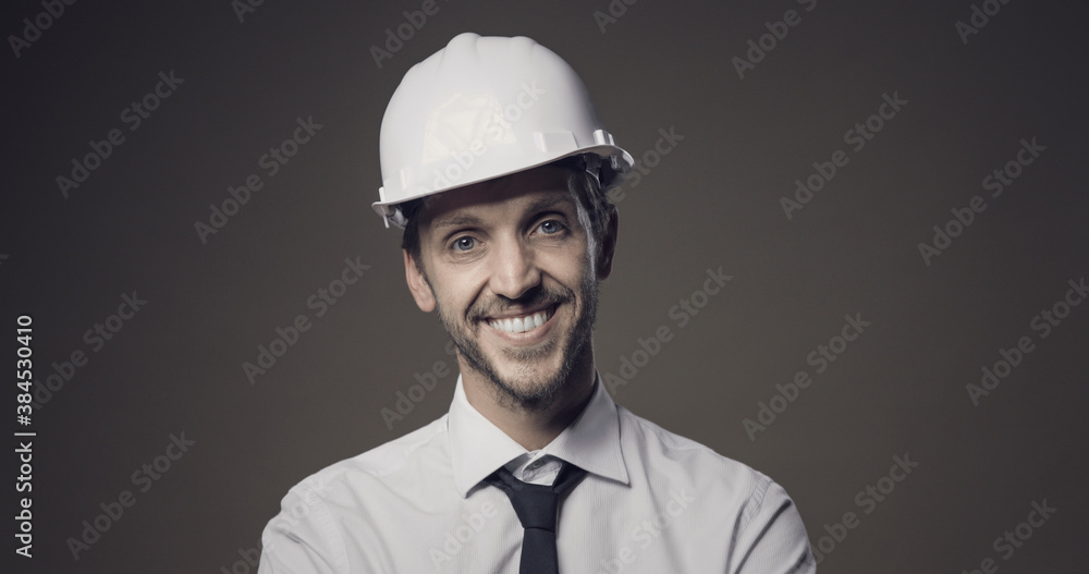 Confident architect smiling and wearing a safety helmet Confident architect smiling and wearing a safety helmet
