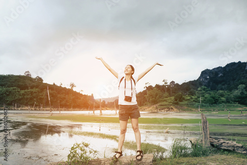 woman tourist and camera standing at mountain valley nature open arms feeling peaceful joyful happy success