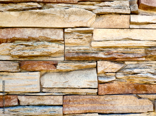 the texture of the wall is made of uneven stones of different sizes of sand and light brown color.. stone background